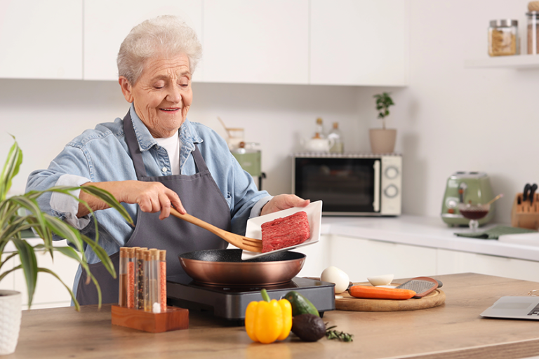 senior woman frying minced meat