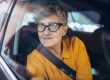 Senior,Woman,With,Glasses,Sitting,In,A,Car.,Shot,Through