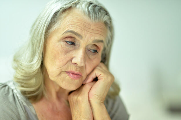 Portrait of a sad elderly woman posing at home