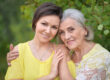 Beautiful elderly woman with her daughter walking in park