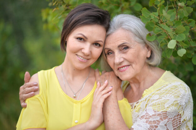 Beautiful elderly woman with her daughter walking in park Beautiful elderly woman with her daughter walking in park